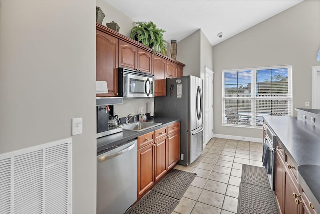 6542 Lakeview Cir, Canal Winchester, OH 43110 - kitchen with appliances with stainless steel finishes, a sink, dark countertops, light tile patterned floors, and high vaulted ceiling