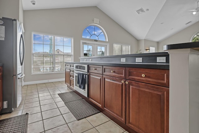 6542 Lakeview Cir, Canal Winchester, OH 43110 - kitchen with stainless steel appliances, vaulted ceiling, dark countertops, a ceiling fan, and light tile patterned floors