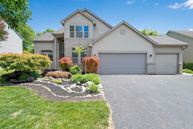 272 Trail E, Etna, OH 43062 - traditional home with brick siding, a garage, driveway, and roof with shingles
