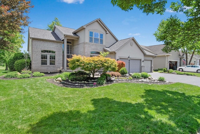 272 Trail E, Etna, OH 43062 - view of front facade with driveway, a garage, a front lawn, and brick siding