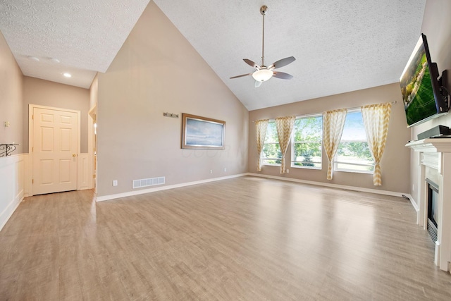 272 Trail E, Etna, OH 43062 - unfurnished living room with a textured ceiling, light wood-style flooring, ceiling fan, a glass covered fireplace, and high vaulted ceiling