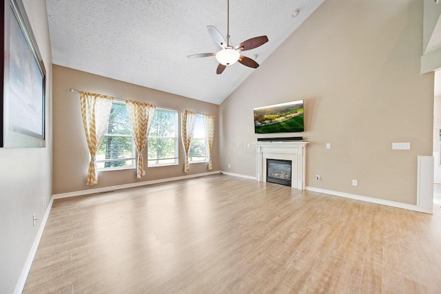272 Trail E, Etna, OH 43062 - unfurnished living room with a glass covered fireplace, a ceiling fan, wood finished floors, high vaulted ceiling, and baseboards
