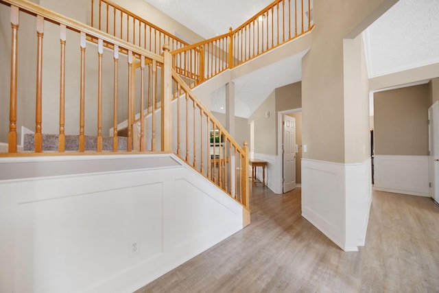 272 Trail E, Etna, OH 43062 - stairway with wood finished floors, a towering ceiling, wainscoting, and a decorative wall