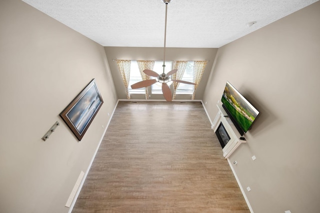 272 Trail E, Etna, OH 43062 - unfurnished living room featuring a textured ceiling, baseboards, wood finished floors, and ceiling fan