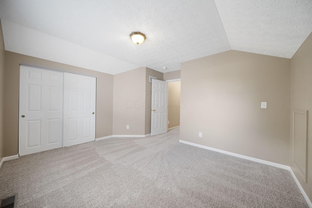 272 Trail E, Etna, OH 43062 - unfurnished bedroom featuring lofted ceiling, baseboards, light carpet, a textured ceiling, and a closet