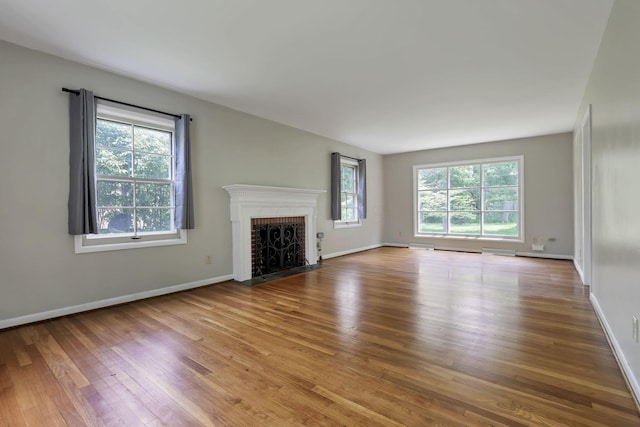 498 Manor, Newark, OH 43055 - unfurnished living room featuring plenty of natural light, wood finished floors, a brick fireplace, and baseboards