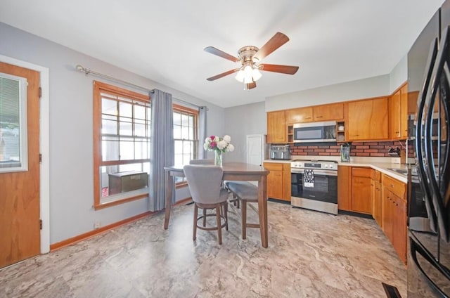 164 Sturbridge Rd, Columbus, OH 43228 - kitchen with stainless steel appliances, a ceiling fan, light countertops, backsplash, and baseboards