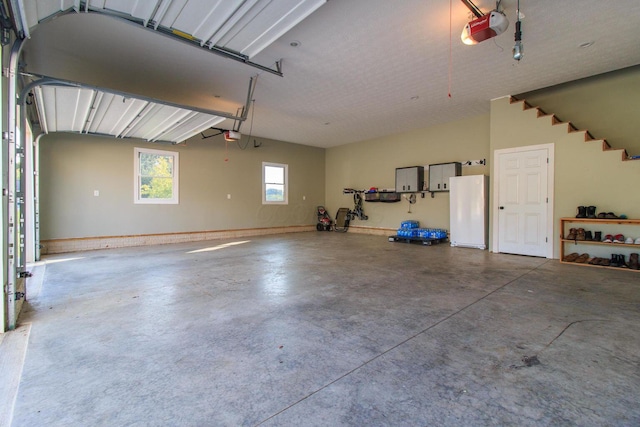 8270 Windy Hollow Rd, Johnstown, OH 43031 - garage featuring a garage door opener and freestanding refrigerator