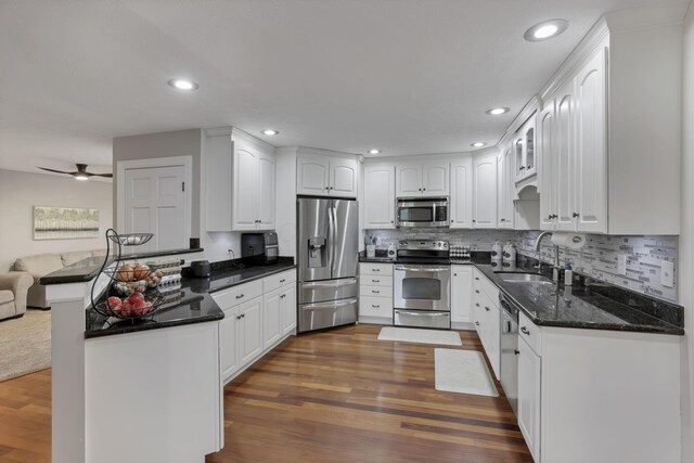 8270 Windy Hollow Rd, Johnstown, OH 43031 - kitchen featuring stainless steel appliances, a sink, a peninsula, dark wood-style flooring, and white cabinetry