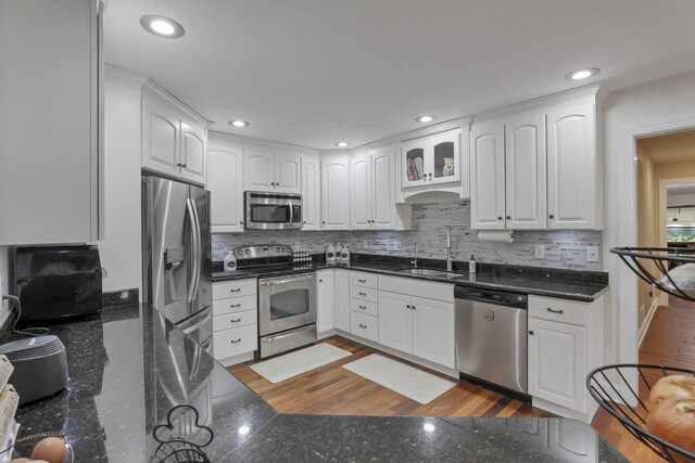 8270 Windy Hollow Rd, Johnstown, OH 43031 - kitchen featuring appliances with stainless steel finishes, a sink, white cabinets, decorative backsplash, and recessed lighting