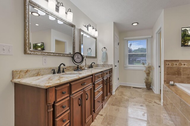 8270 Windy Hollow Rd, Johnstown, OH 43031 - bathroom with double vanity, a garden tub, a textured ceiling, and baseboards