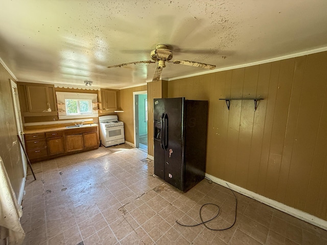 140 Sycamore St, Glouster, OH 45732 - kitchen featuring black refrigerator with ice dispenser, white gas stove, a ceiling fan, brown cabinetry, and a sink
