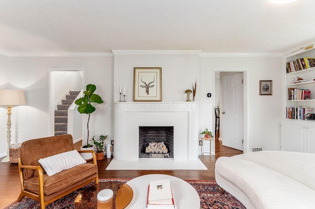 232 N Stanwood Rd, Columbus, OH 43209 - living area featuring wood finished floors, crown molding, a fireplace with flush hearth, and baseboards