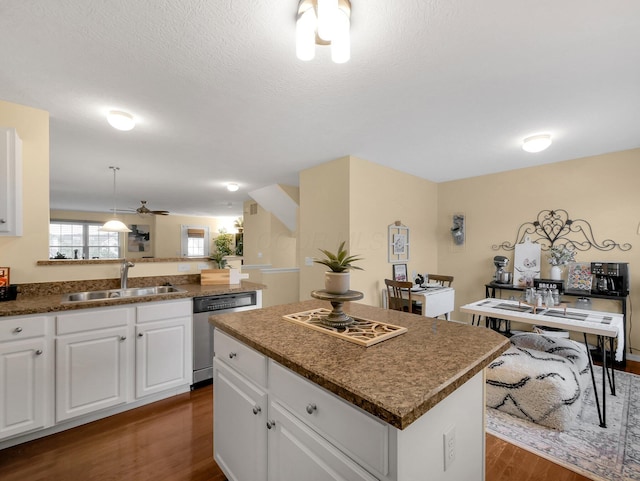 6010 Turnwood Dr Unit 703, Westerville, OH 43081 - kitchen featuring stainless steel dishwasher, a sink, dark wood-style floors, a kitchen island, and white cabinetry