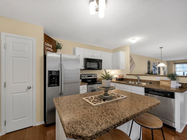 6010 Turnwood Dr Unit 703, Westerville, OH 43081 - kitchen featuring appliances with stainless steel finishes, a sink, a peninsula, white cabinetry, and dark wood finished floors