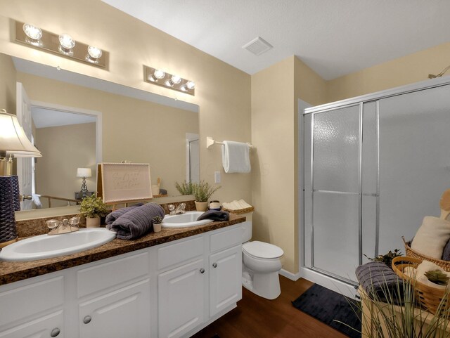 6010 Turnwood Dr Unit 703, Westerville, OH 43081 - bathroom featuring double vanity, toilet, a stall shower, and wood finished floors