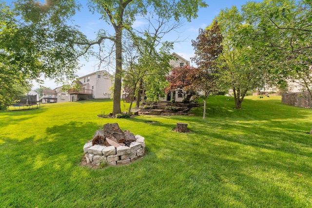 369 Highbanks Valley Ct, Newark, OH 43055 - view of grassy yard featuring a fire pit, a trampoline, and a deck