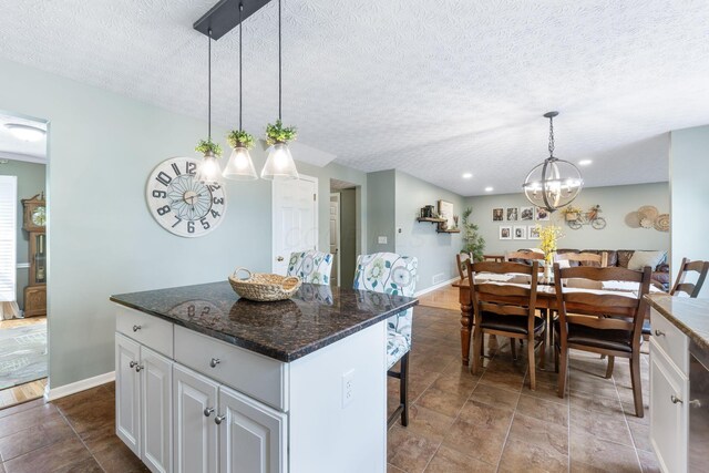 369 Highbanks Valley Ct, Newark, OH 43055 - kitchen featuring a textured ceiling, a chandelier, white cabinetry, a kitchen island, and decorative light fixtures