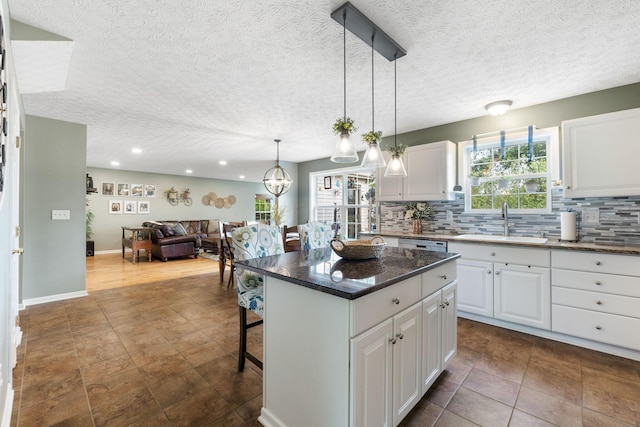369 Highbanks Valley Ct, Newark, OH 43055 - kitchen featuring a breakfast bar area, open floor plan, tasteful backsplash, white cabinetry, and a center island
