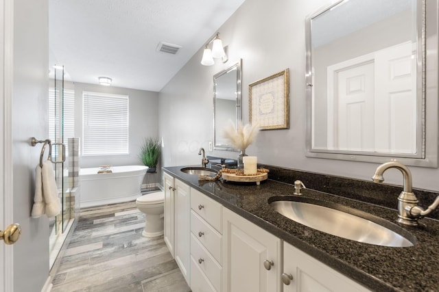 369 Highbanks Valley Ct, Newark, OH 43055 - bathroom featuring double vanity, a freestanding bath, wood finished floors, and a stall shower