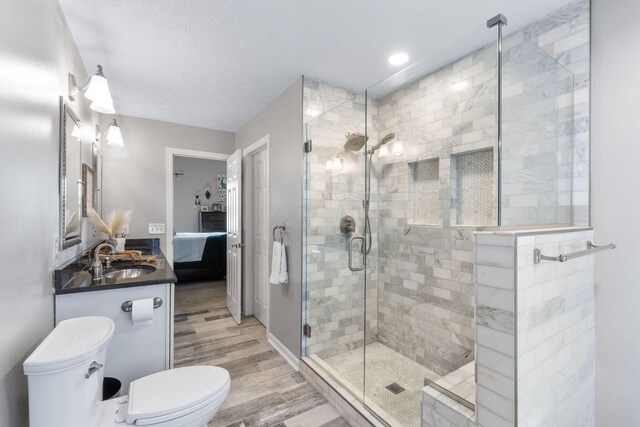 369 Highbanks Valley Ct, Newark, OH 43055 - bathroom featuring a shower stall, connected bathroom, vanity, wood finished floors, and a textured ceiling