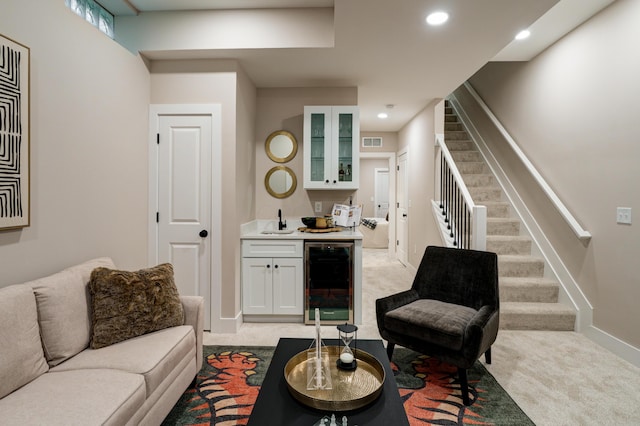2587 Dayton Ave, Columbus, OH 43202 - living room featuring beverage cooler, bar with sink, stairs, light colored carpet, and baseboards