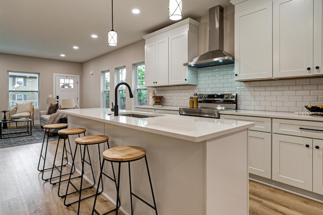 2587 Dayton Ave, Columbus, OH 43202 - kitchen with wall chimney range hood, electric range, a sink, light wood-type flooring, and recessed lighting