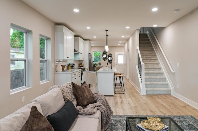 2587 Dayton Ave, Columbus, OH 43202 - living room featuring light wood-type flooring, stairs, recessed lighting, and baseboards