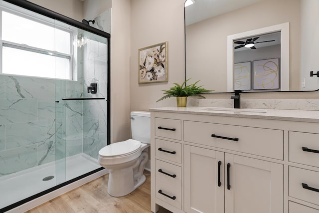 2587 Dayton Ave, Columbus, OH 43202 - bathroom with toilet, vanity, a marble finish shower, wood finished floors, and a ceiling fan