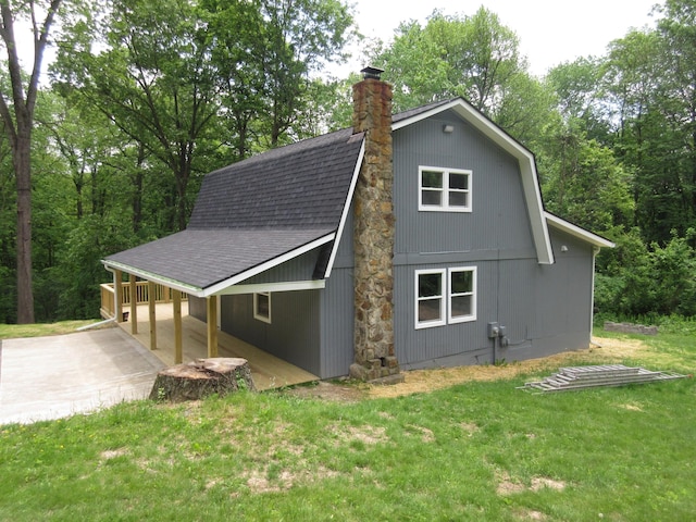 3814 London Hollow Rd NE, Newark, OH 43055 - view of side of home with a shingled roof, concrete driveway, a lawn, a chimney, and an attached carport