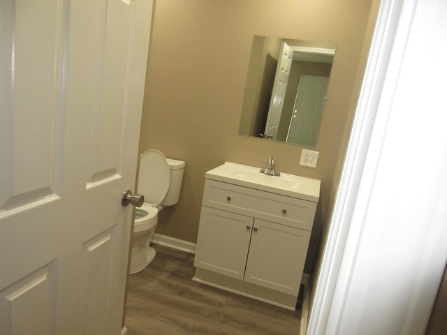 3814 London Hollow Rd NE, Newark, OH 43055 - half bathroom with toilet, wood finished floors, vanity, and baseboards