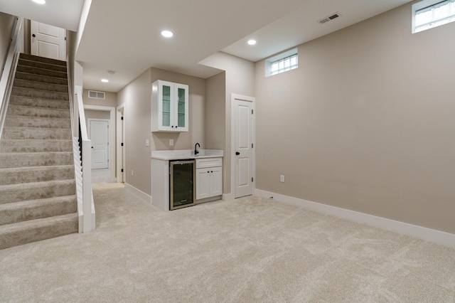 2589 Dayton Ave, Columbus, OH 43202 - kitchen with wine cooler, a sink, white cabinets, glass insert cabinets, and healthy amount of natural light