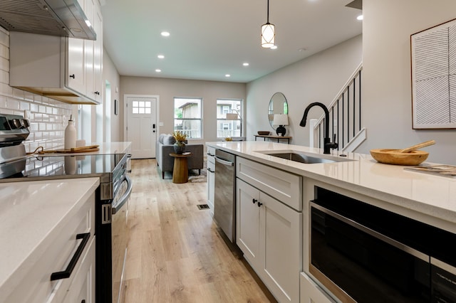 2589 Dayton Ave, Columbus, OH 43202 - kitchen featuring black range with electric cooktop, a sink, built in microwave, range hood, and light wood finished floors