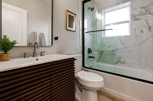 2589 Dayton Ave, Columbus, OH 43202 - full bath featuring toilet, combined bath / shower with glass door, vanity, and wood finished floors