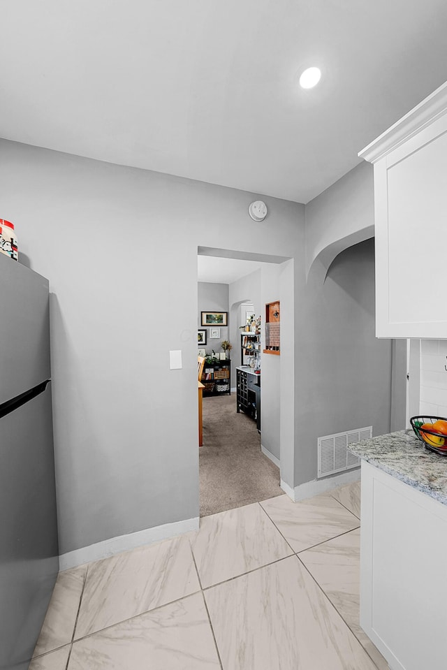 1081 Harrisburg Pike, Columbus, OH 43223 - kitchen with freestanding refrigerator, white cabinets, light stone counters, and baseboards