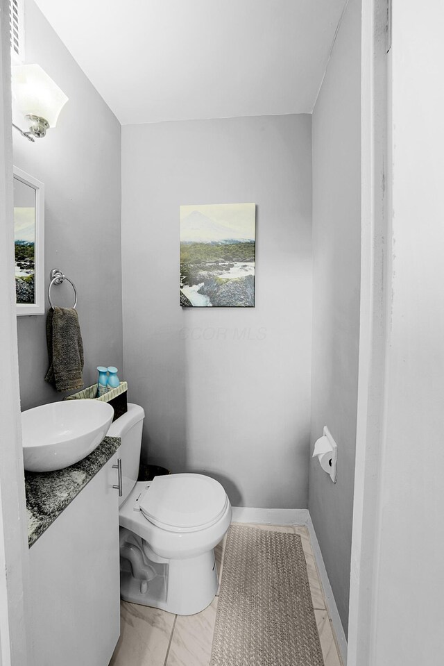 1081 Harrisburg Pike, Columbus, OH 43223 - half bathroom featuring toilet, vanity, and marble finish flooring