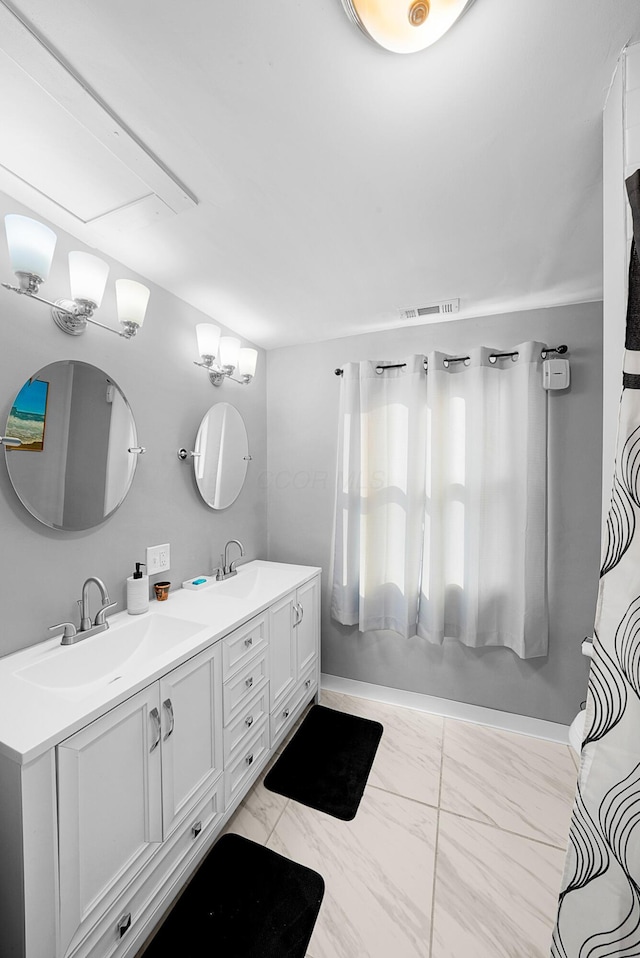 1081 Harrisburg Pike, Columbus, OH 43223 - bathroom with double vanity, marble look tiles, and baseboards
