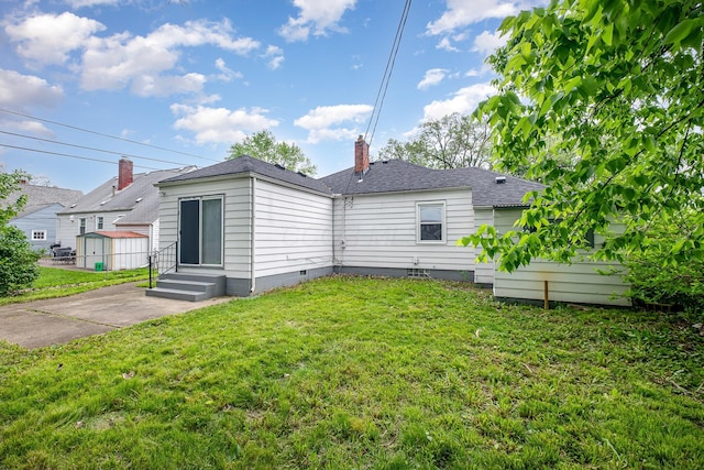 2845 Homecroft Dr, Columbus, OH 43211 - back of house featuring entry steps, a yard, crawl space, a chimney, and roof with shingles