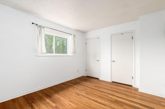 1824 Willoway Cir S, Columbus, OH 43220 - unfurnished bedroom featuring light wood-style flooring, baseboards, and two closets