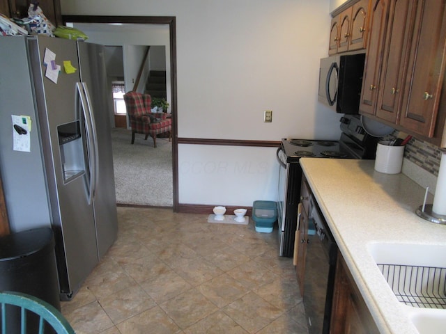 302 W Hubert Ave, Lancaster, OH 43130 - kitchen featuring black appliances, light countertops, brown cabinetry, tasteful backsplash, and a sink