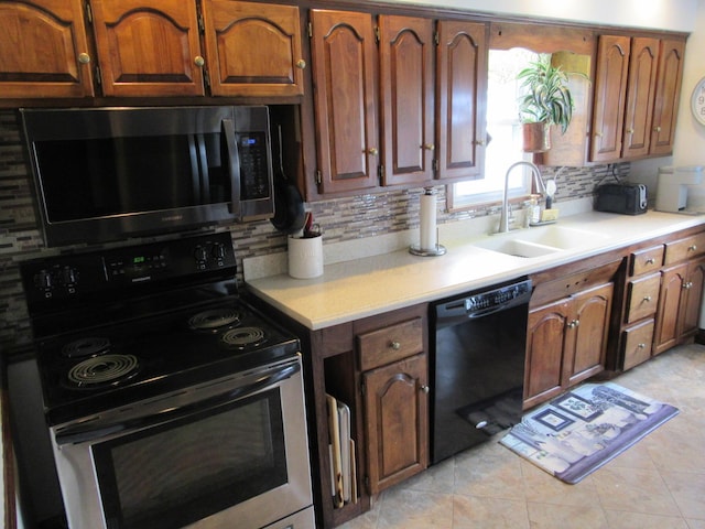 302 W Hubert Ave, Lancaster, OH 43130 - kitchen with stainless steel appliances, a sink, tasteful backsplash, light countertops, and light tile patterned floors