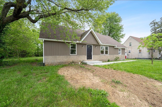 202 Toland St, London, OH 43140 - view of front facade with a shingled roof, a front yard, and stone siding