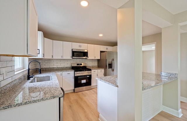 202 Toland St, London, OH 43140 - kitchen with appliances with stainless steel finishes, a sink, light wood finished floors, light stone counters, and recessed lighting