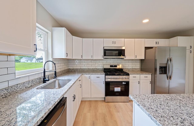 202 Toland St, London, OH 43140 - kitchen with stainless steel appliances, a sink, white cabinetry, light stone counters, and light wood finished floors