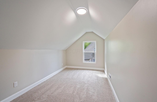 202 Toland St, London, OH 43140 - additional living space with lofted ceiling, light colored carpet, and baseboards