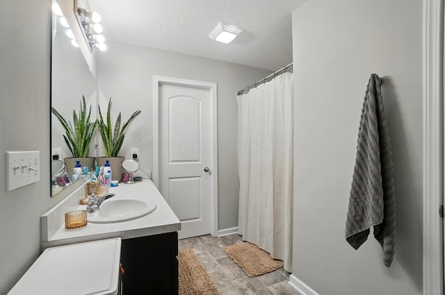 5416 Branchville Dr, Canal Winchester, OH 43110 - full bathroom featuring vanity, wood finished floors, baseboards, curtained shower, and a textured ceiling
