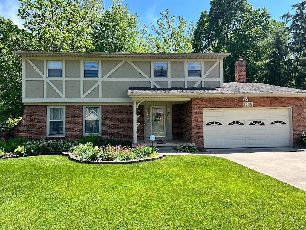 1795 Laylon Dr, Columbus, OH 43229 - english style home with a front yard, concrete driveway, an attached garage, brick siding, and a chimney