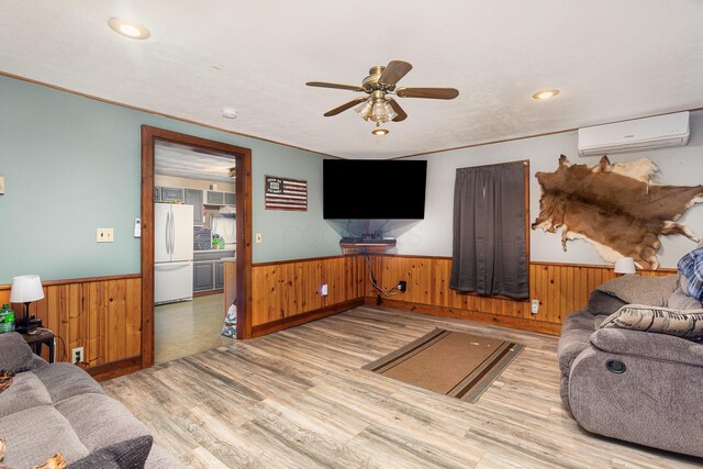 14552 Snyder Rd, Richwood, OH 43344 - living room with a wall mounted AC, wood finished floors, wainscoting, wooden walls, and a ceiling fan