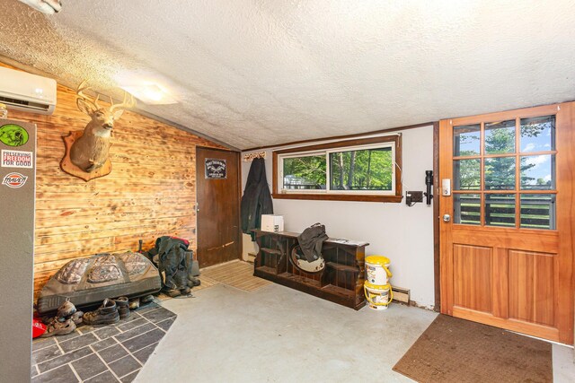 14552 Snyder Rd, Richwood, OH 43344 - sitting room featuring a textured ceiling, concrete floors, wooden walls, an AC wall unit, and vaulted ceiling