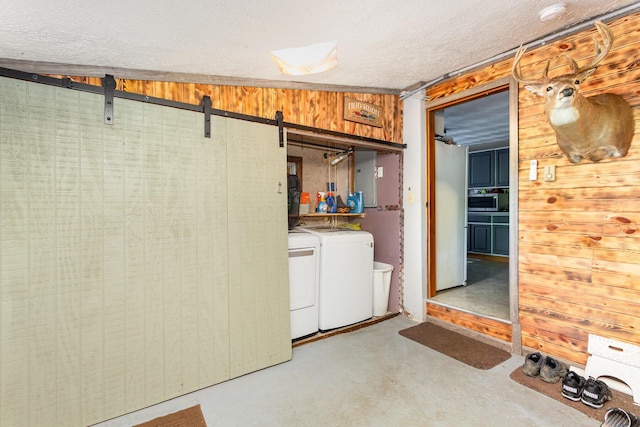 14552 Snyder Rd, Richwood, OH 43344 - basement featuring washing machine and clothes dryer, a textured ceiling, and a barn door